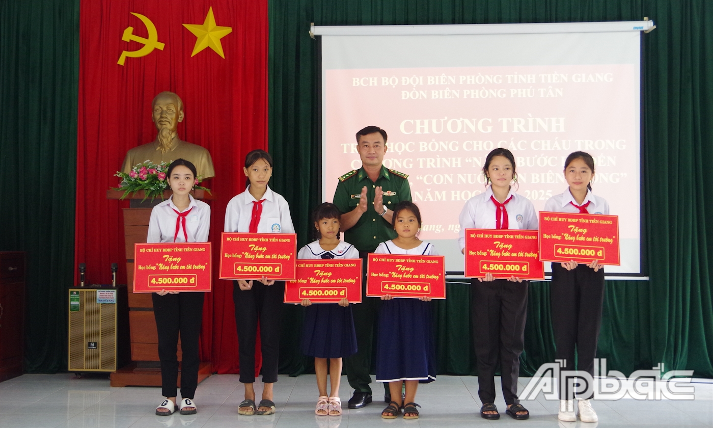Thượng tá Nguyễn Quốc Thanh, Phó Chính ủy BĐBP Tiền Giang trao tặng học bổng cho các em học sinh trong chương trình “Nâng bước em tới trường”.
