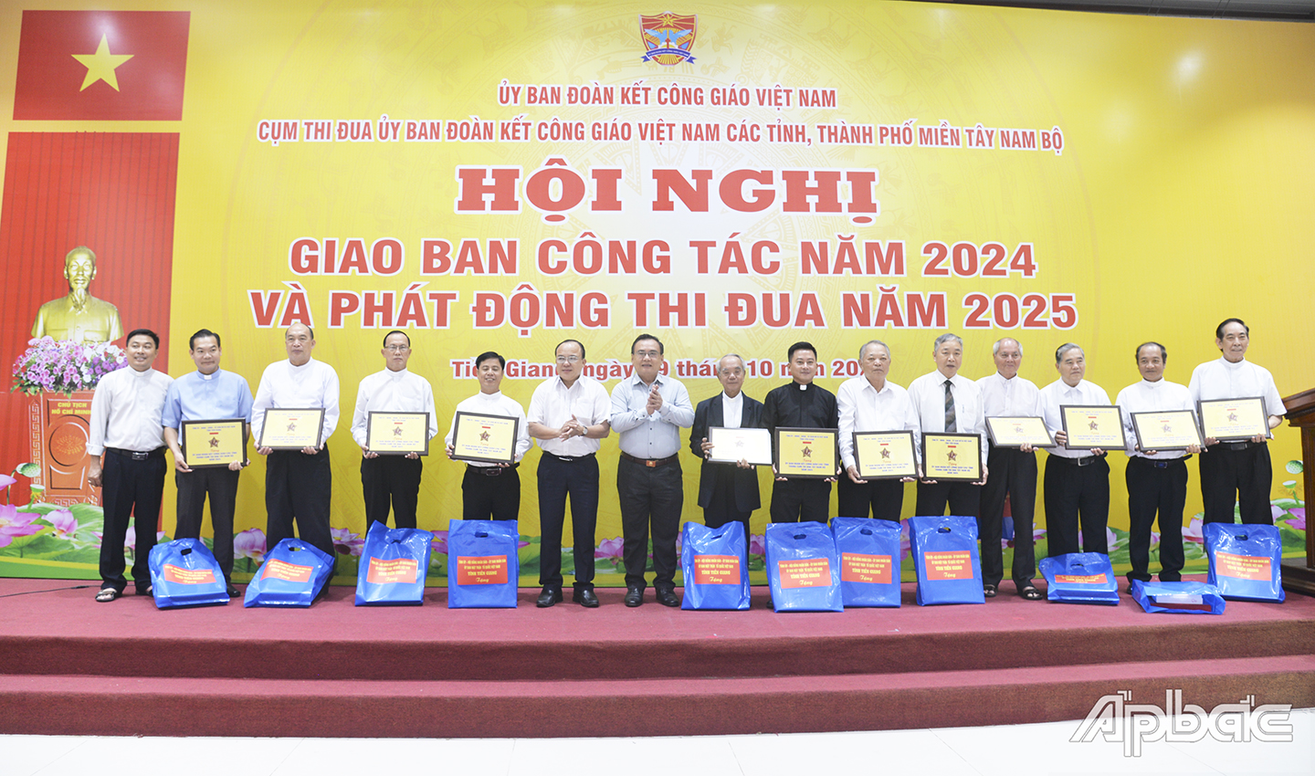 Đồng chí Võ Văn Bình, Phó Bí thư Thường trực Tỉnh ủy, Chủ tịch HĐND tỉnh và đồng chí Nguyễn Chí Trung, Ủy viên Ban Thường vụ Tỉnh ủy, Chủ tịch Ủy ban MTTQ tỉnh Tiền Giang tặng quà lưu niệm cho lãnh đạo Ủy ban ĐKCG các tỉnh tham dự hội nghị