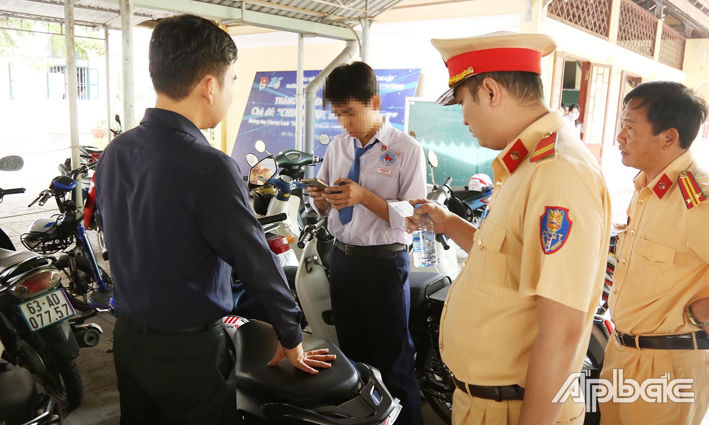 Kiểm tra giấy phép lái xe của 1 học sinh đủ điều kiện điều khiển xe máy trên 50Cc tại bãi xe trường THPT  Nguyễn Đình Chiểu.