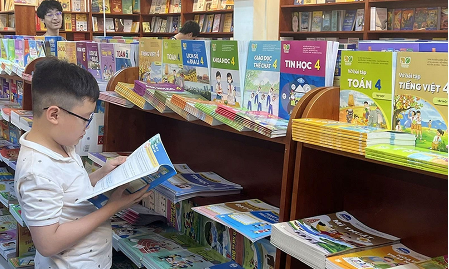 Học sinh lựa chọn sách giáo khoa tại nhà sách. (Ảnh NGUYÊN KHÔI)