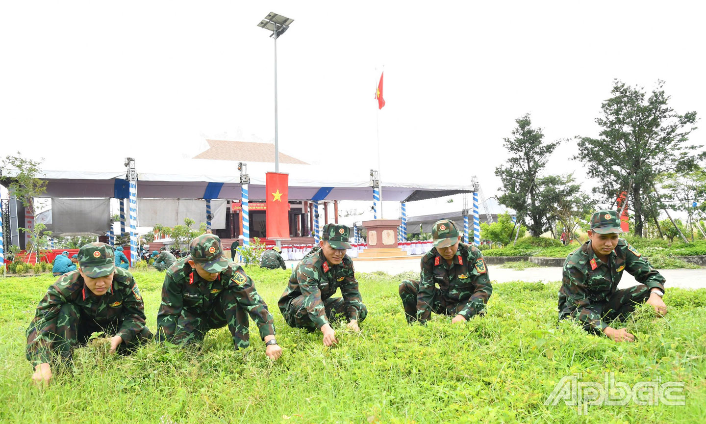 Cán bộ, chiến sĩ lực lượng vũ trang tỉnh dọn vệ sinh môi trường trong khuôn viên Khu tưởng niệm đồng chí Phan Văn Khỏe.