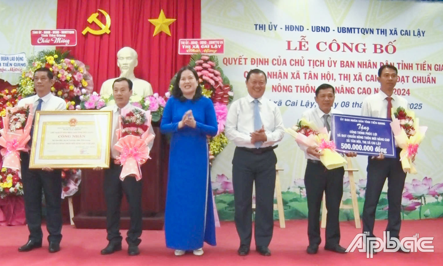 Đồng chí Phan Phùng Phú, Ủy viên Ban Thường vụ Tỉnh ủy, Bí thư Thị ủy, Chủ tịch HĐND TX. Cai Lậy và đồng chí Trần Thị Bé Bảy, Phó Giám đốc Sở Nông nghiệp và Phát triển nông thôn trao Bằng công nhận xã đạt chuẩn nông thôn mới nâng cao và Bảng tượng trưng tặng công trình phúc lợi cho xã Tân Hội.                                                                                       Ảnh: NGUYỄN BẢY