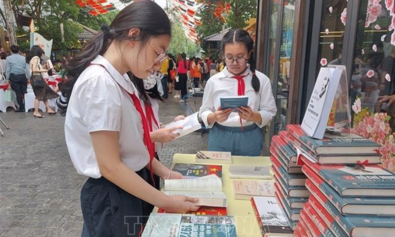 Học sinh tìm hiểu về sách tại Phố sách Hà Nội. Ảnh tư liệu: Đinh Thuận/TTXVN