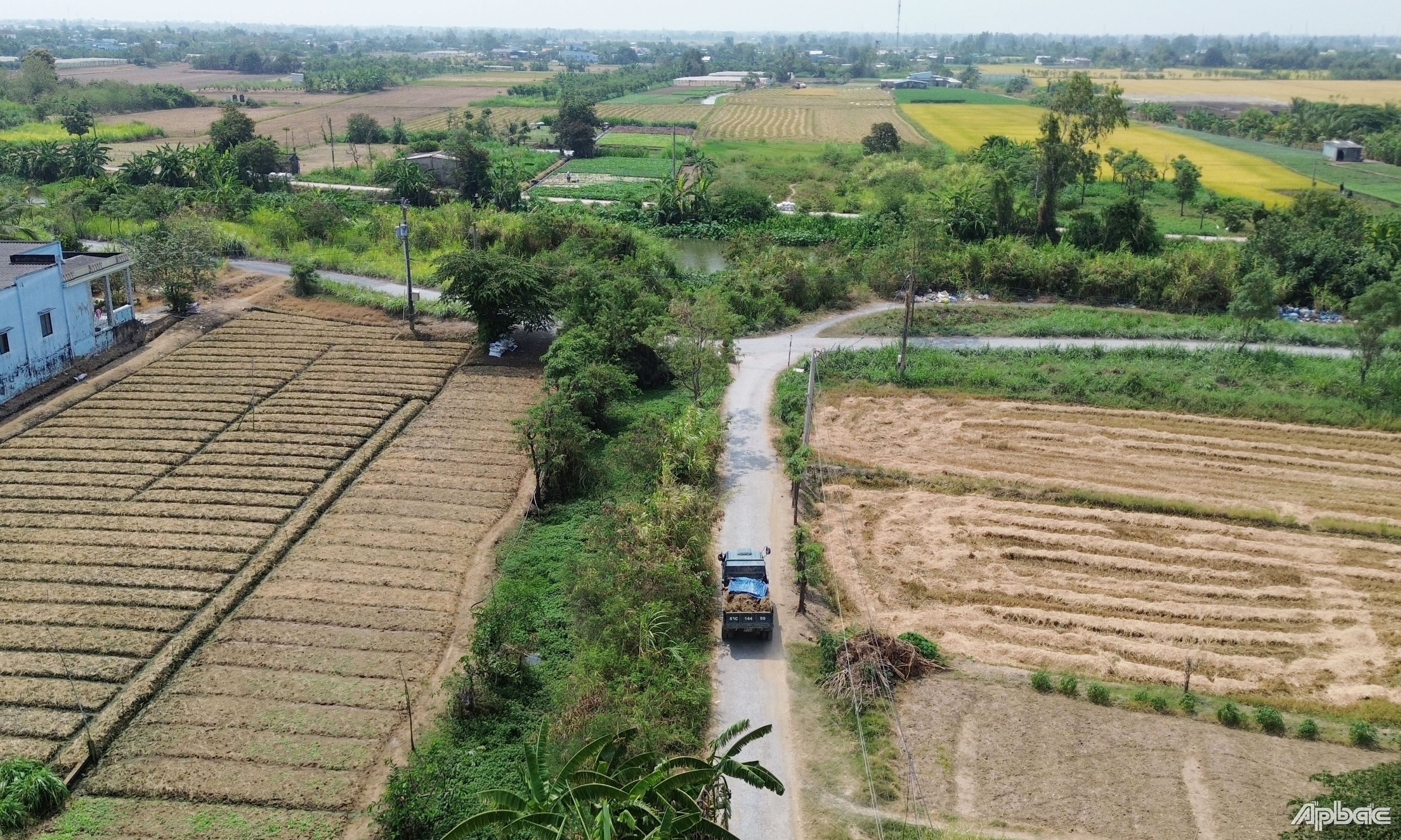 Xe tải chở đất di chuyển chiếm gần hết phần đường giao thông nông thôn và che đậy chỉ 1 nửa thùng xe.