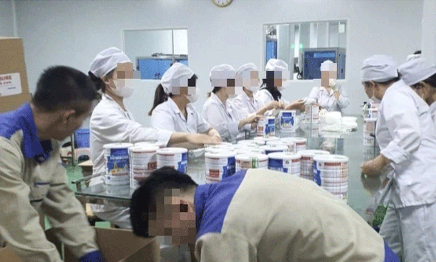 Công nhân đóng hộp thành phẩm tại cơ sở sản xuất sữa bột giả quy mô lớn vừa bị Công an thành phố Hà Nội triệt phá. (Ảnh: Báo Công an nhân dân)