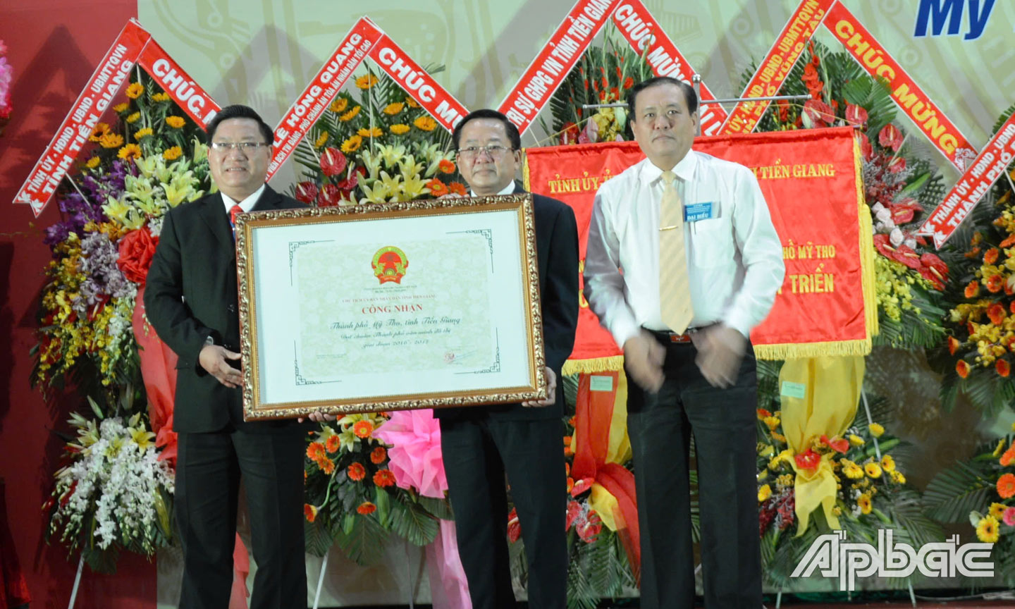 Phó Chủ tịch UBND tỉnh Lê Văn Nghĩa trao Quyết định của UBND tỉnh công nhận TP. Mỹ Tho đạt chuẩn văn minh đô thị giai đoạn 2016 - 2017. Ảnh: HẠNH NGA