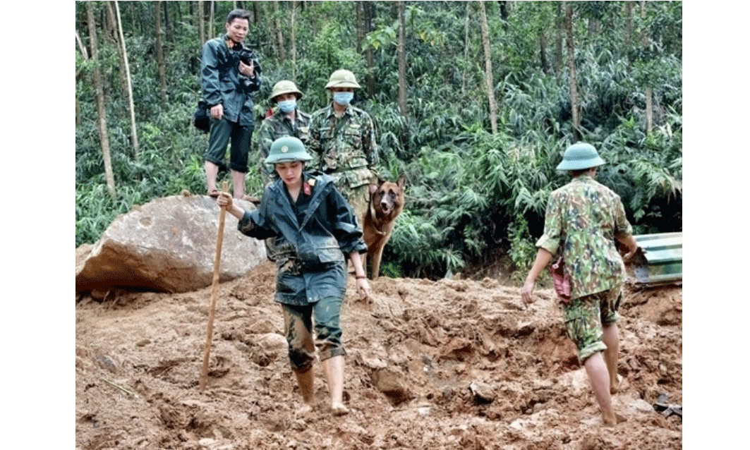 Phóng viên Báo Quân đội nhân dân tác nghiệp tại vùng lũ. 