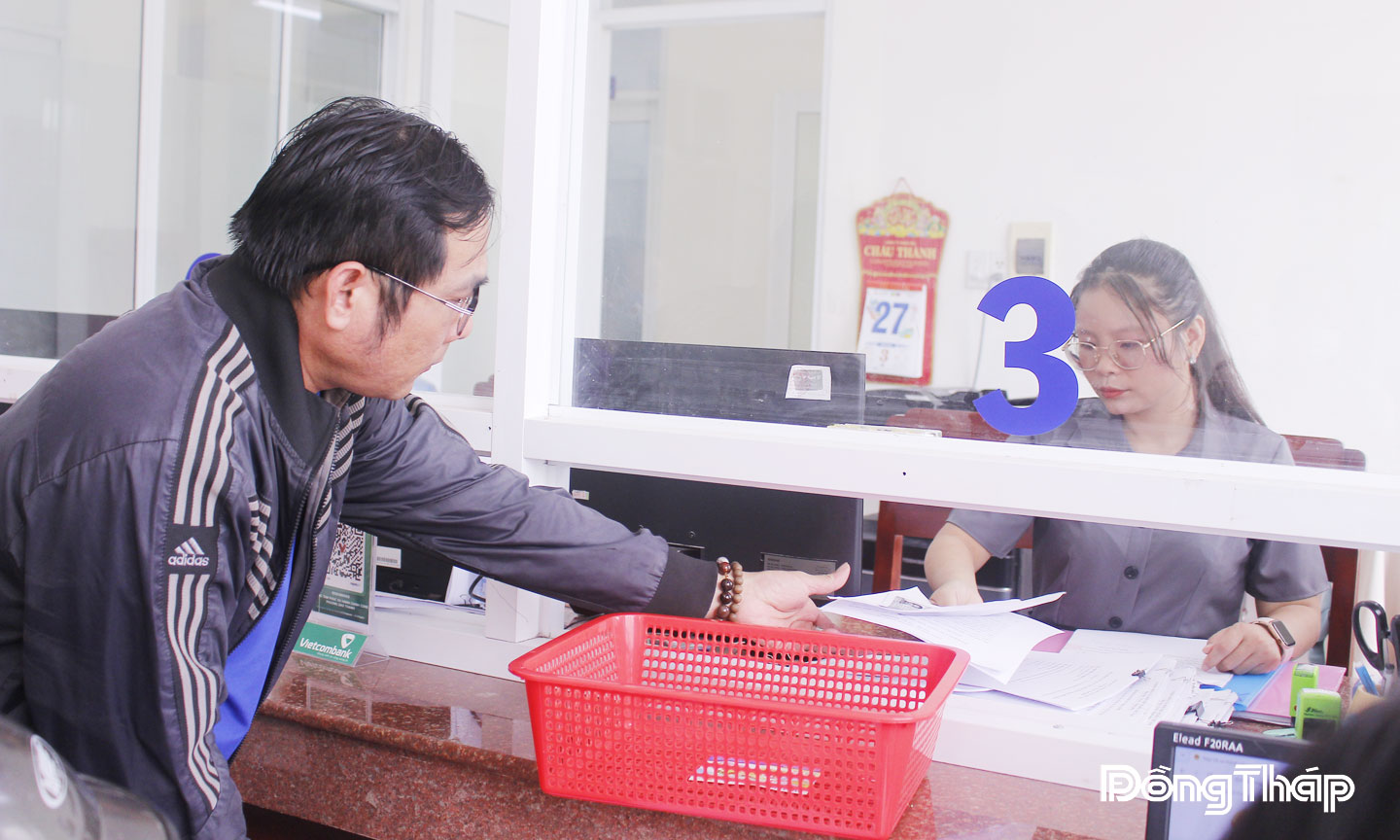 Cán bộ, công chức hướng dẫn người dân làm thủ tục hành chính tại Trung tâm Phục vụ hành chính công phường Đạo Thạnh. 