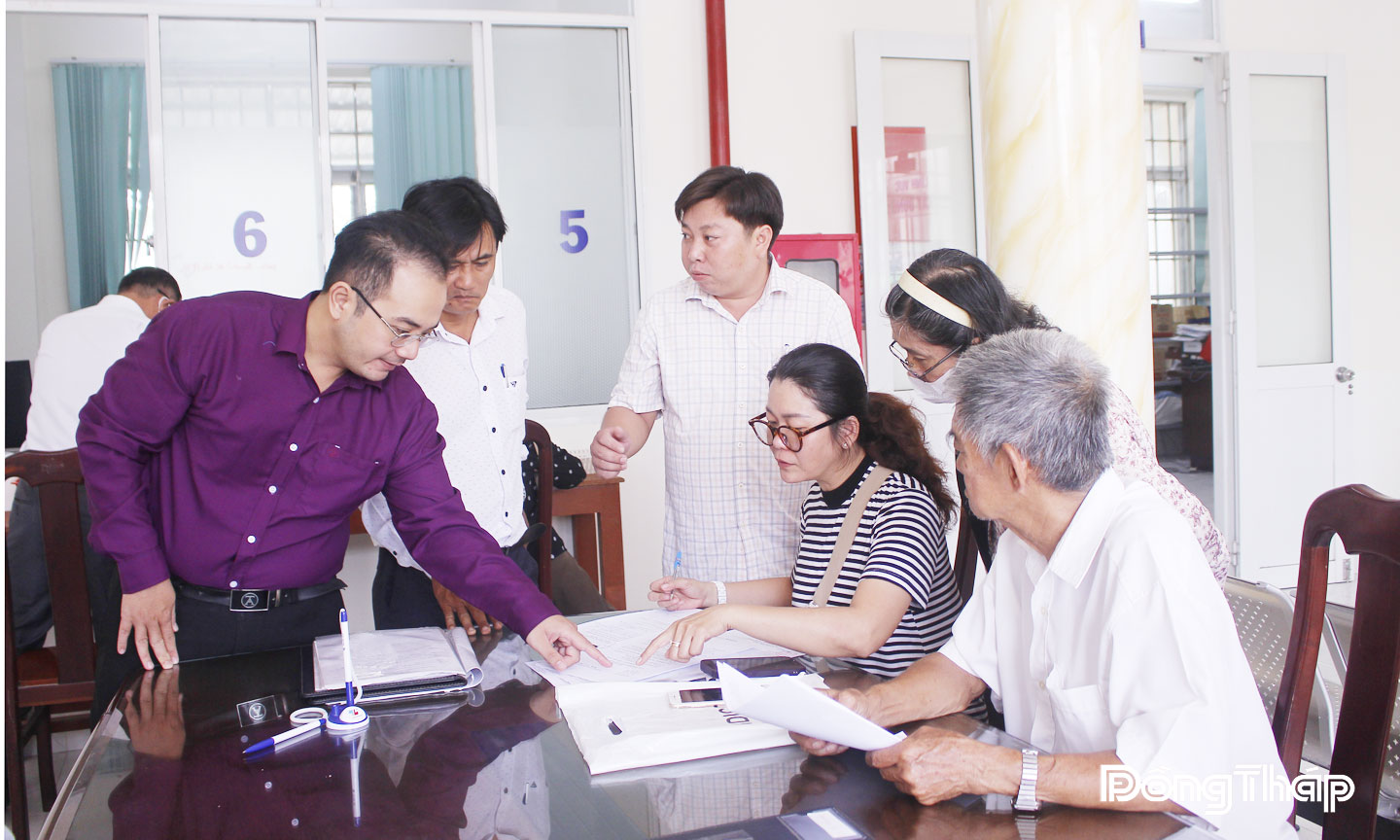 Cán bộ, công chức hướng dẫn người dân làm thủ tục hành chính tại Trung tâm Phục vụ hành chính công phường Đạo Thạnh. 