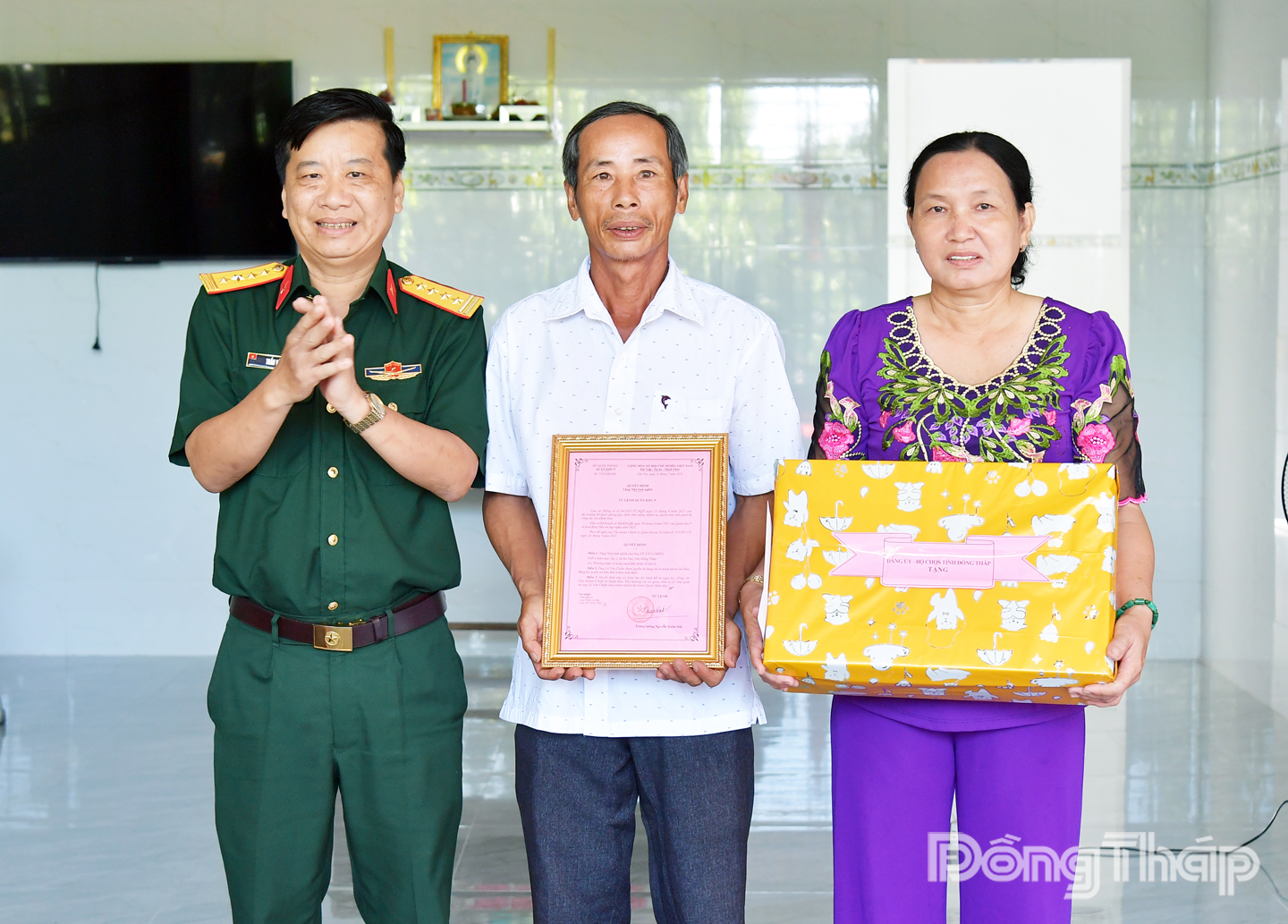Đại tá Trần Văn Hiền, Phó Chính ủy Bộ Chỉ huy Quân sự tỉnh Đồng Tháp (bìa trái) trao quyết định tặng căn “Nhà tình nghĩa” và tặng quà cho ông Lê Văn Chiến.