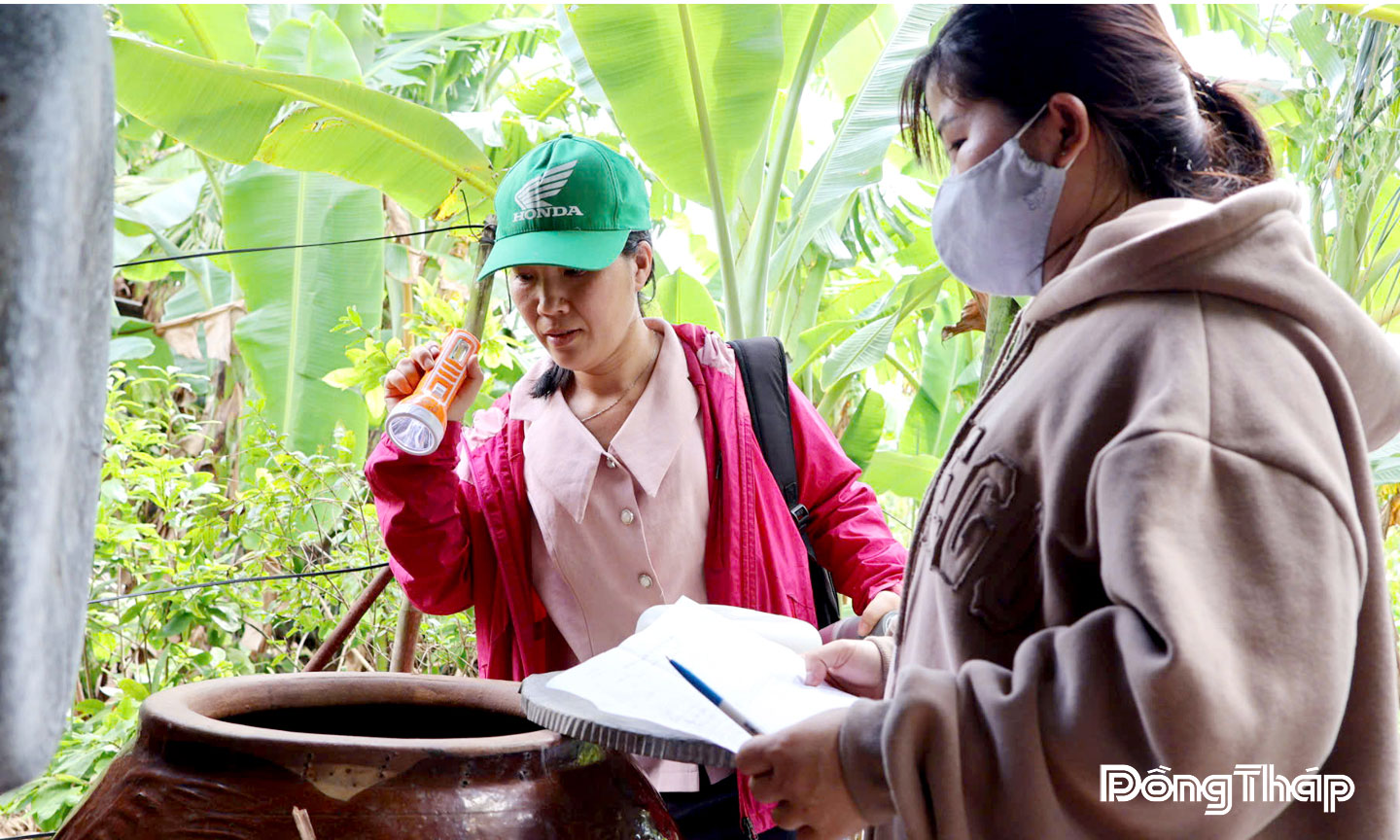 Thành viên Đoàn giám sát Sở Y tế kiểm tra ăng quăng trong dụng cụ chứa nước tại nhà người dân ở xã Mỹ Thọ.