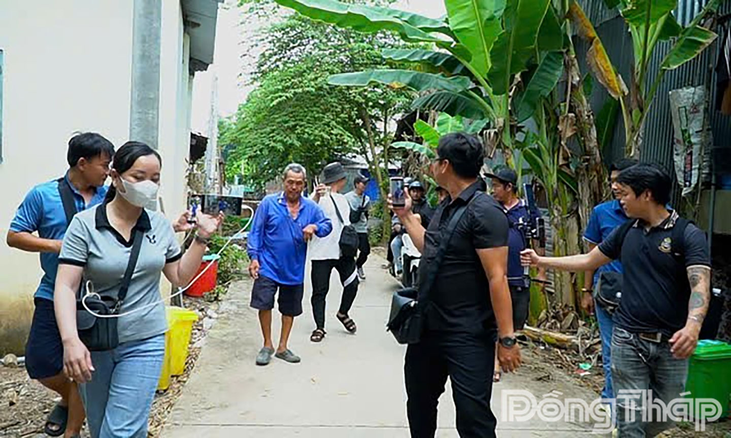 Từ ngoài cổng Đình thần Tân Long, nhiều YouTuber, TikToker,… trong và ngoài tỉnh đến ghi hình, phỏng vấn ông M. Ảnh: Phòng An ninh mạng/ Công an Đồng Tháp