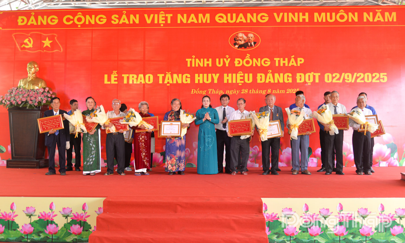 Đồng chí Nguyễn Hải Trâm, Phó Bí thư Thường trực Tỉnh ủy trao Huy hiệu Đảng cho đảng viên và đồng chí Nguyễn Văn Mười, Ủy viên Ban Thường vụ Tỉnh ủy, Trưởng Ban Tổ chức Tỉnh ủy tặng hoa chúc mừng các đồng chí được tặng Huy hiệu 60 năm tuổi Đảng.