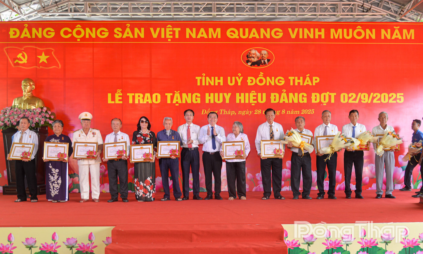 Đồng chí Trần Trí Quang, Phó Bí thư Tỉnh ủy, Chủ tịch UBND tỉnh trao Huy hiệu Đảng cho đảng viên và đồng chí Phan Văn Thương, Ủy viên Ban Thường vụ Tỉnh ủy, Trưởng Ban Nội chính Tỉnh ủy tặng hoa chúc mừng các đồng chí được tặng Huy hiệu 55 năm tuổi Đảng.