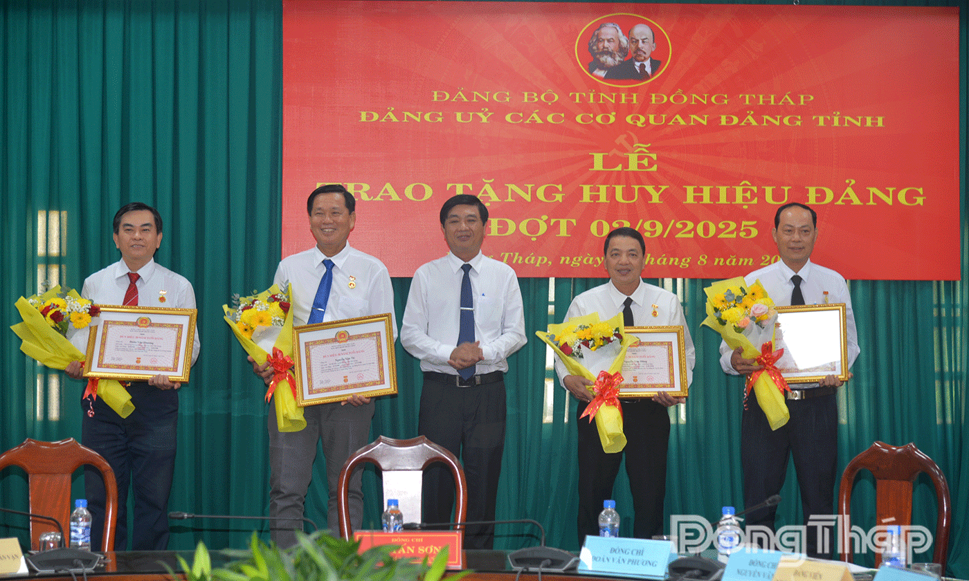 Đồng chí Lê Tấn Sơn, Phó Bí thư Đảng ủy các cơ quan Đảng tỉnh trao Huy hiệu cho các đảng viên.