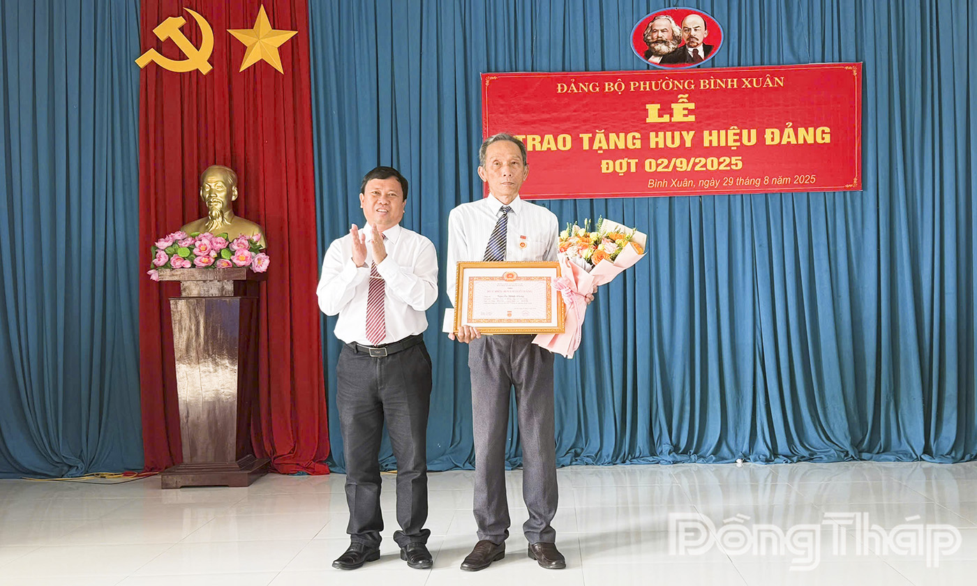 Đồng chí Huỳnh Tuấn Dũng, Bí thư Đảng ủy, Chủ tịch Hội đồng nhân dân phường trao Huy hiệu Đảng cho đảng viên.