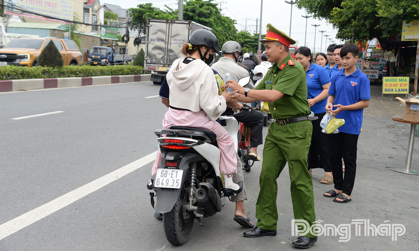 Phát nước suối, khăn lạnh, thức ăn nhanh miễn phí cho người dân trên tuyến Quốc lộ 60 đoạn qua phường Trung An.