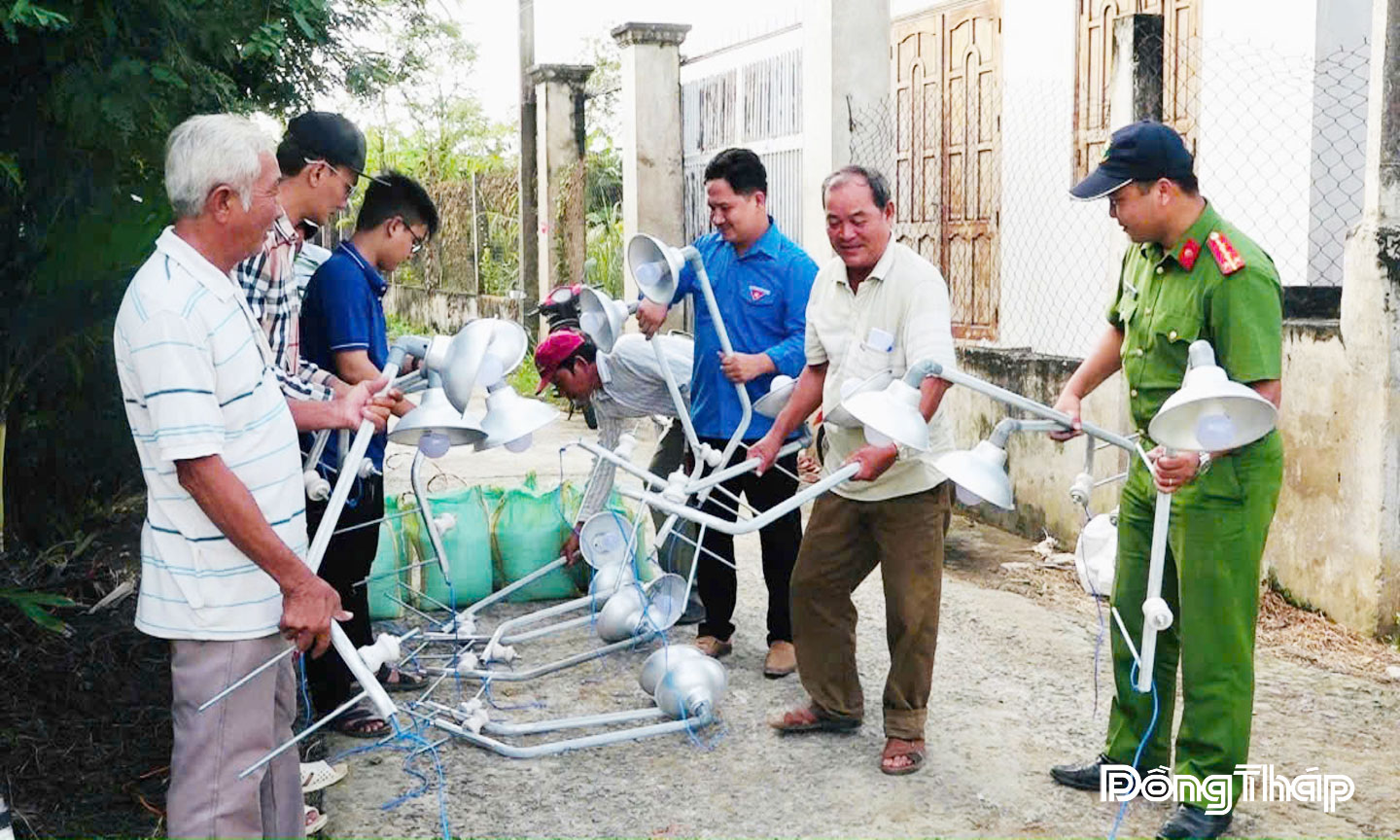 Lực lượng Công an xã Long Bình và người dân khu dân cư lắp đặt đèn đường góp phần giữ gìn an ninh trật tự tại địa phương.