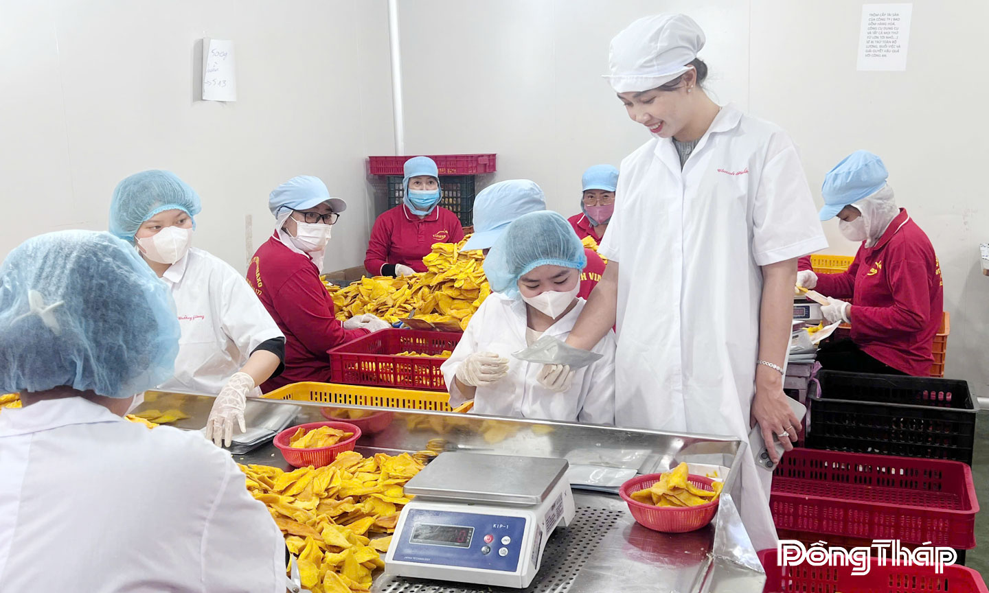 Chị Thảo (đứng) trao đổi với công nhân trong quá trình sản xuất. 