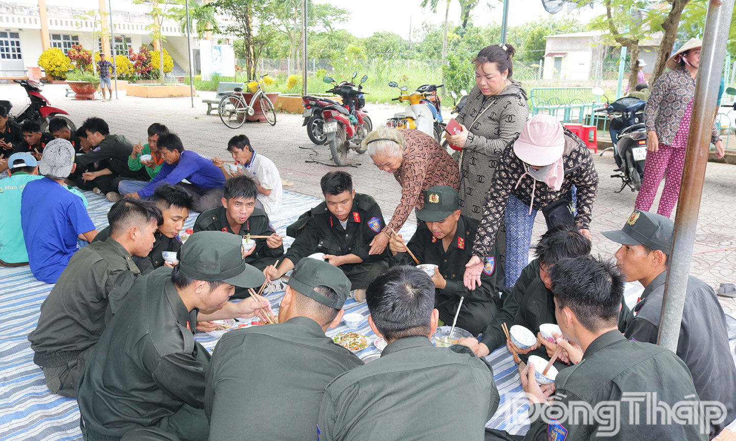 Bữa cơm ấm lòng] Các chiến sĩ Công an cùng ngồi ăn bữa cơm do chính tay người dân nấu nướng. Những hạt cơm đơn sơ nhưng chứa đựng tình cảm chân thành, gắn kết tình quân - dân thắm thiết.