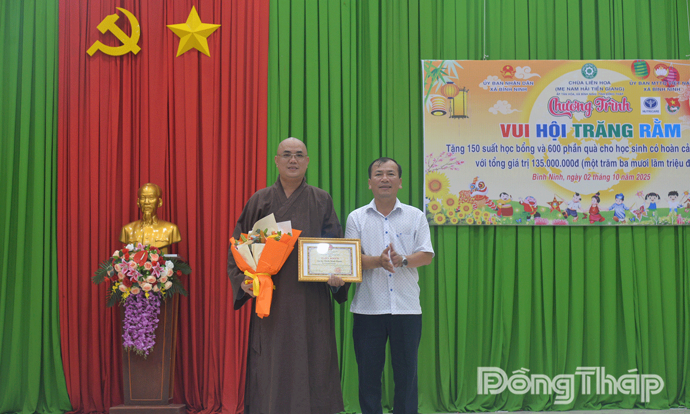 Đồng chí Trần Hoàng Nhật Nam, Bí thư Đảng ủy, Chủ tịch UBND xã Bình Ninh trao thư cảm ơn Đại đức Thích Minh Phước.