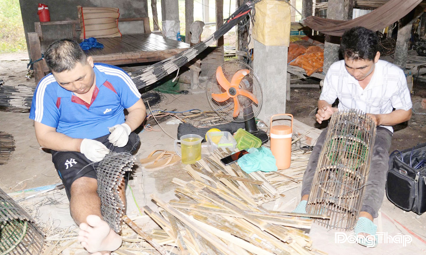 Anh Nguyễn Văn Đoàn (bìa trái) thực hiện công đoạn  đan lọp cua đồng.