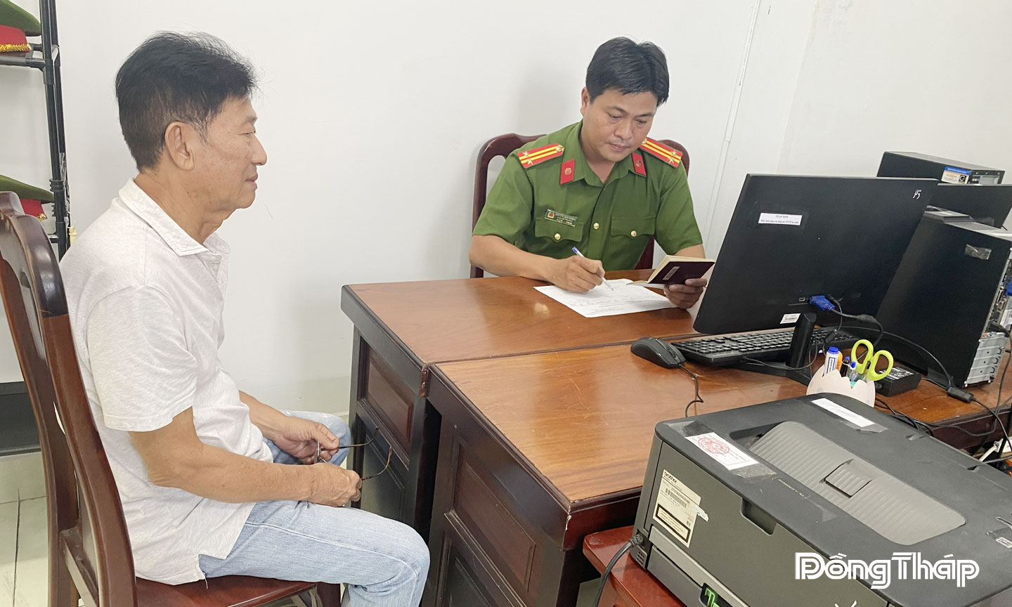 Trung tá Nguyễn Duy Khánh hướng dẫn cho người nước ngoài đăng ký tạm trú trên địa bàn phường.