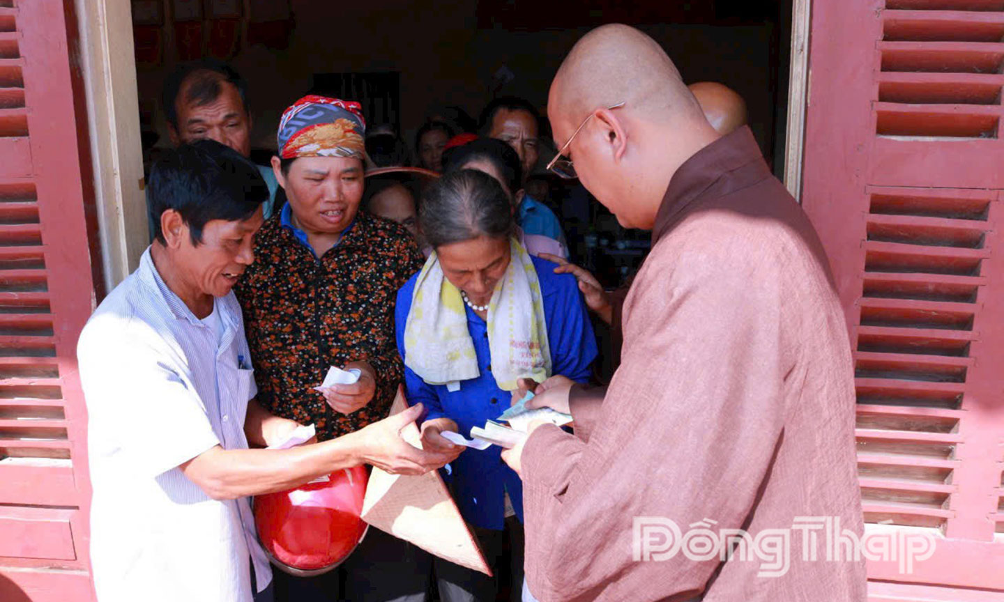 Trao tiền hỗ trợ cho người dân.