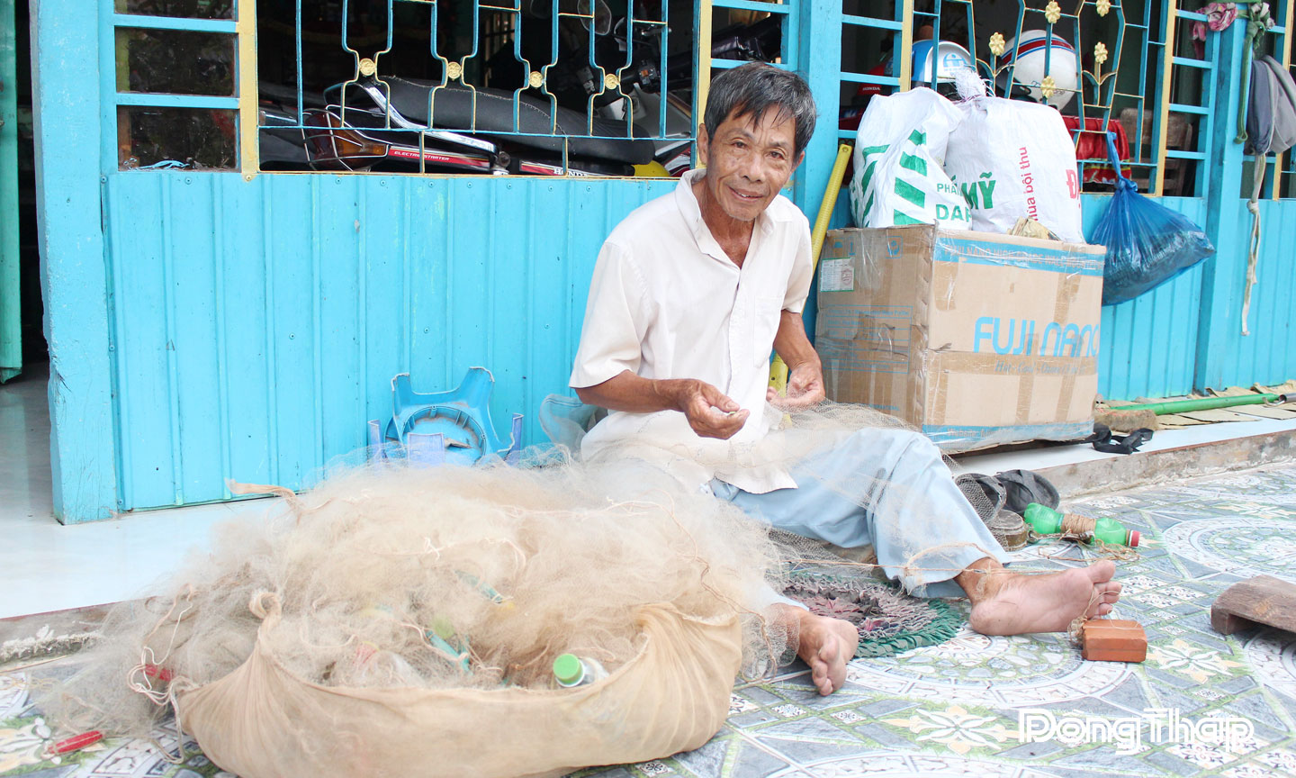 Ông Nguyễn Văn Doãn (73 tuổi, xã Mỹ An Hưng) dặm vá lại  vài tay lưới để đánh bắt cá.
