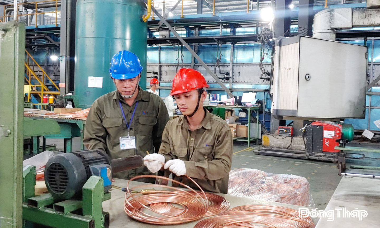 Anh Trần Văn Cưỡng (bên trái) và đồng nghiệp đang làm việc.