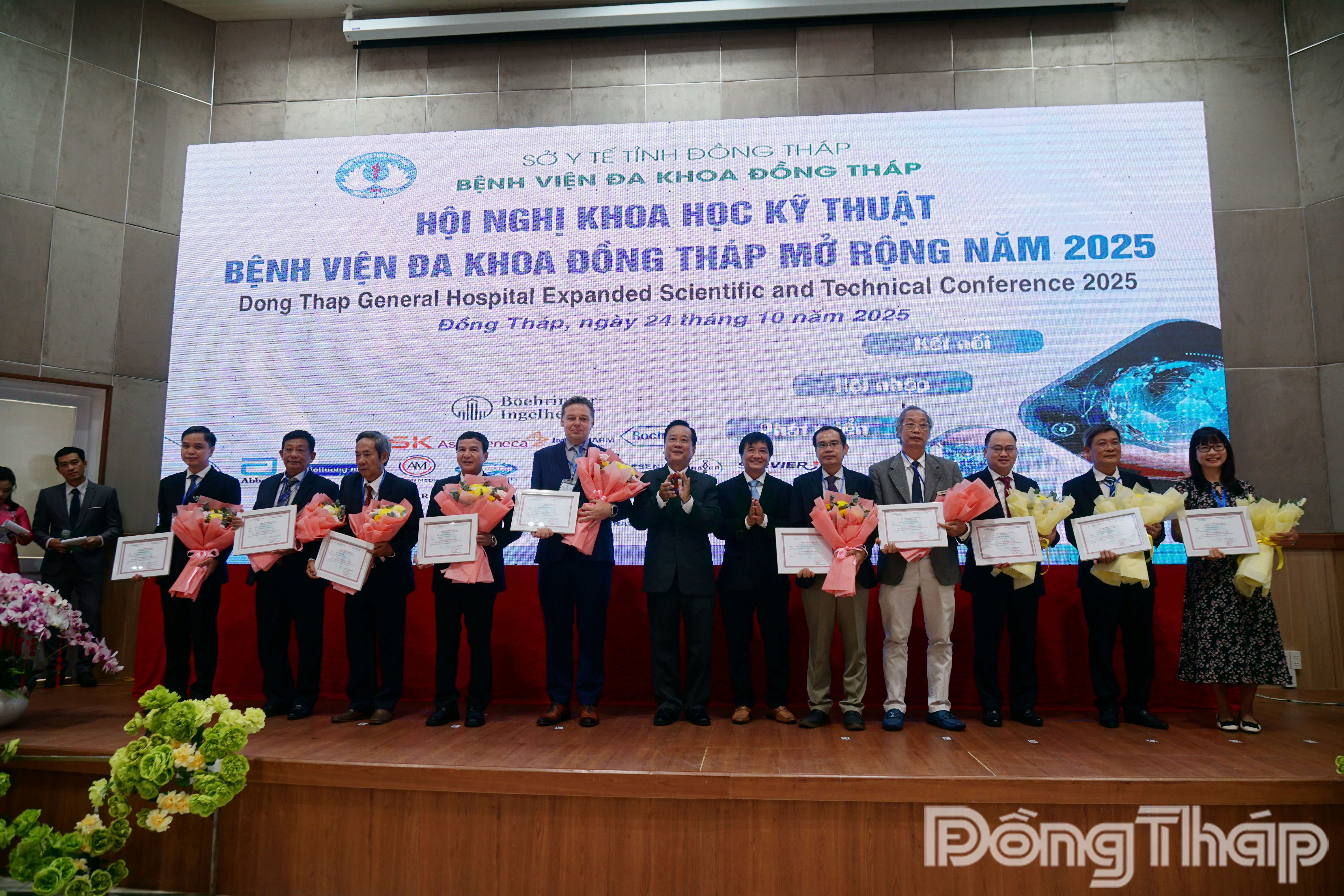 BS.CK2. Tạ Tùng Lâm, Giám đốc Bệnh viện Đa khoa Đồng Tháp (thứ 7 từ phải sang) tặng hoa tri ân chủ tọa và báo cáo viên của Hội nghị