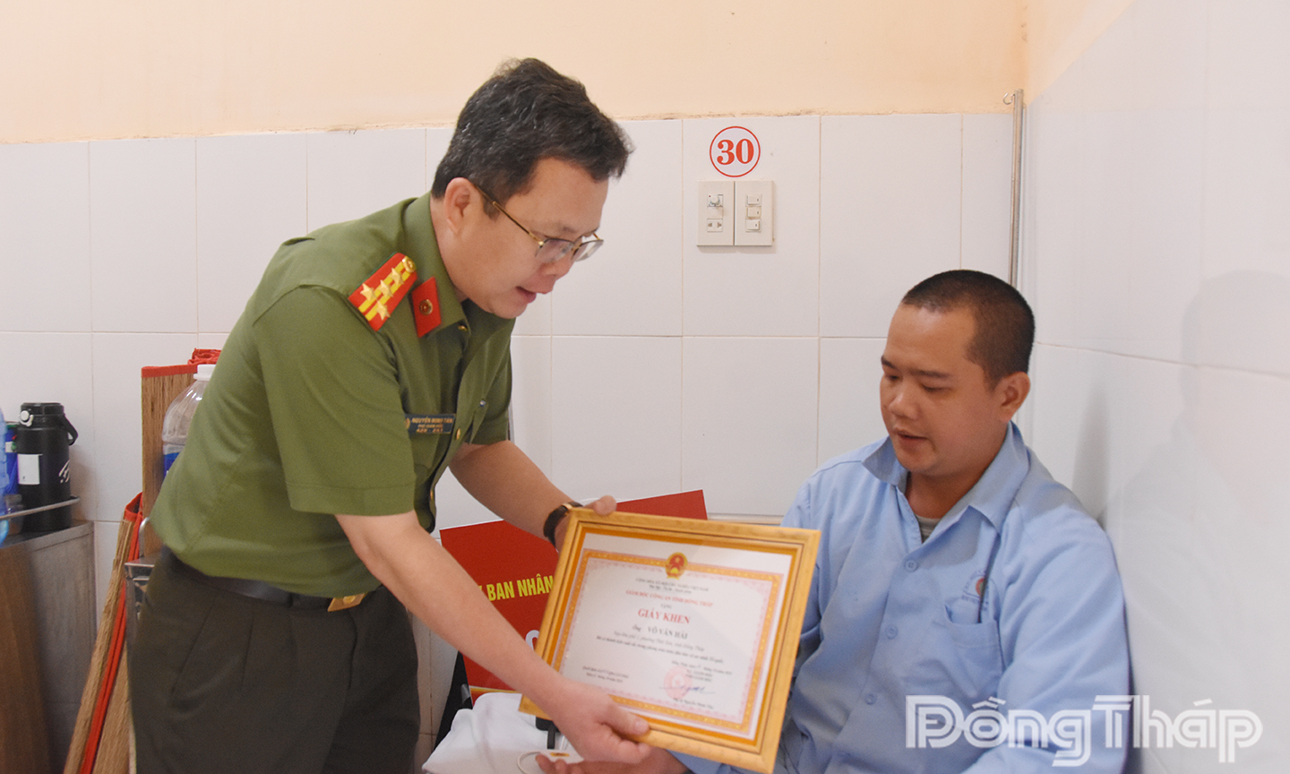 Đồng chí Đại tá Nguyễn Minh Tân, Phó Giám đốc Công an tỉnh trao giấy khen của Giám đốc Công an tỉnh tặng anh Võ Văn Hải