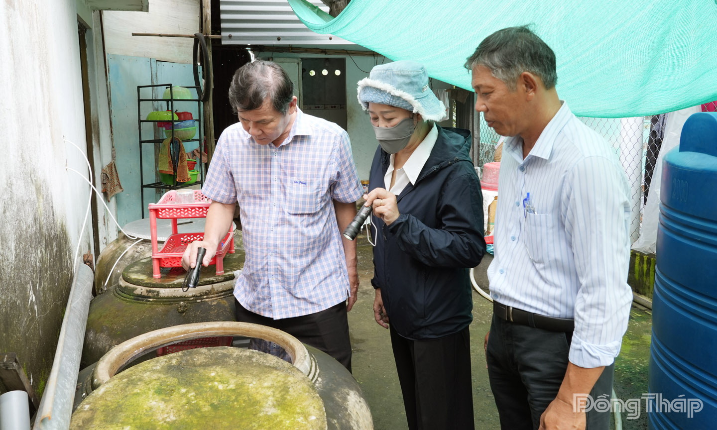 BSCKII Võ Thanh Nhơn (bên trái) kiểm tra lăng quăng tại hộ gia đình Ấp Dương Quới.