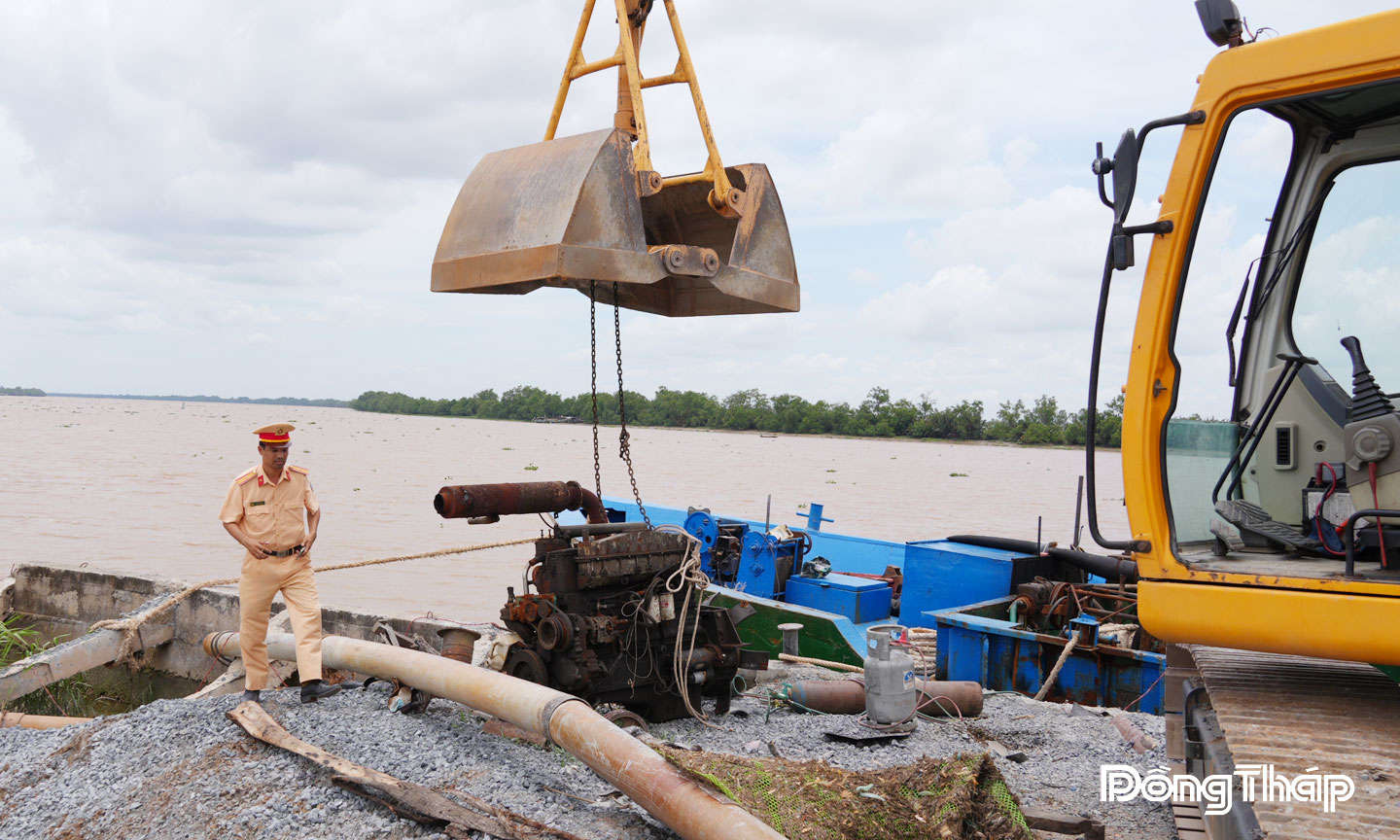 Cảnh sát giao thông Công an tỉnh Đồng Tháp vận động người dân tháo dỡ phương tiện khai thác cát.