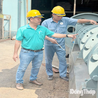 Anh Nguyễn Bá Châu (bên trái) trao đổi với đồng nghiệp về bảo trì vận hành thiết bị tại công ty.