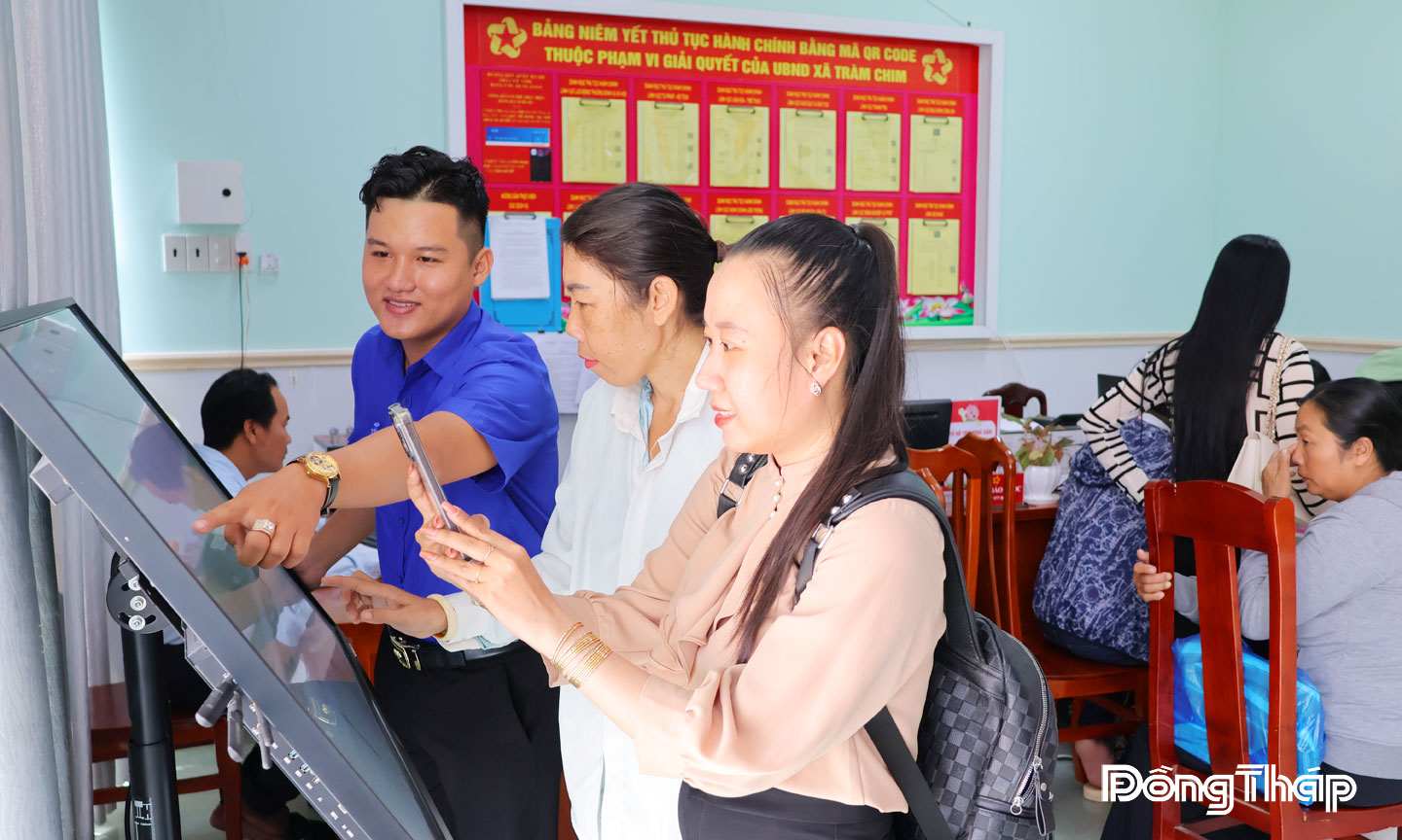 Đoàn viên thanh niên hướng dẫn người dân thực hiện làm thủ tục hành chính qua điện thoại thông minh.