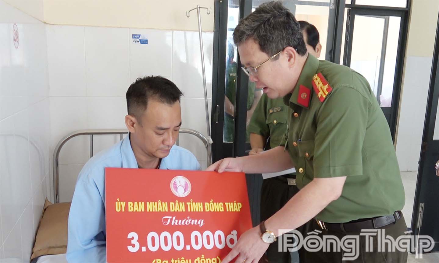 Đại tá Nguyễn Minh Tân, Phó Giám đốc Công an tỉnh trao thưởng của Ủy ban nhân dân tỉnh cho anh Lê Hoàng Thanh.