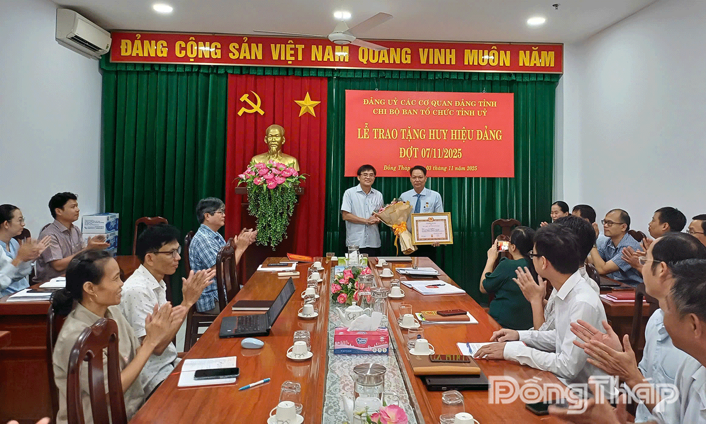 Đồng chí Nguyễn Văn Mười, Ủy viên Ban Thường vụ Tỉnh ủy, Trưởng Ban Tổ chức Tỉnh ủy, Phó Bí thư Thường trực Đảng ủy các Cơ quan Đảng tỉnh Đồng Tháp trao Huy hiệu 30 năm tuổi Đảng cho đồng chí Lê Văn Trung.