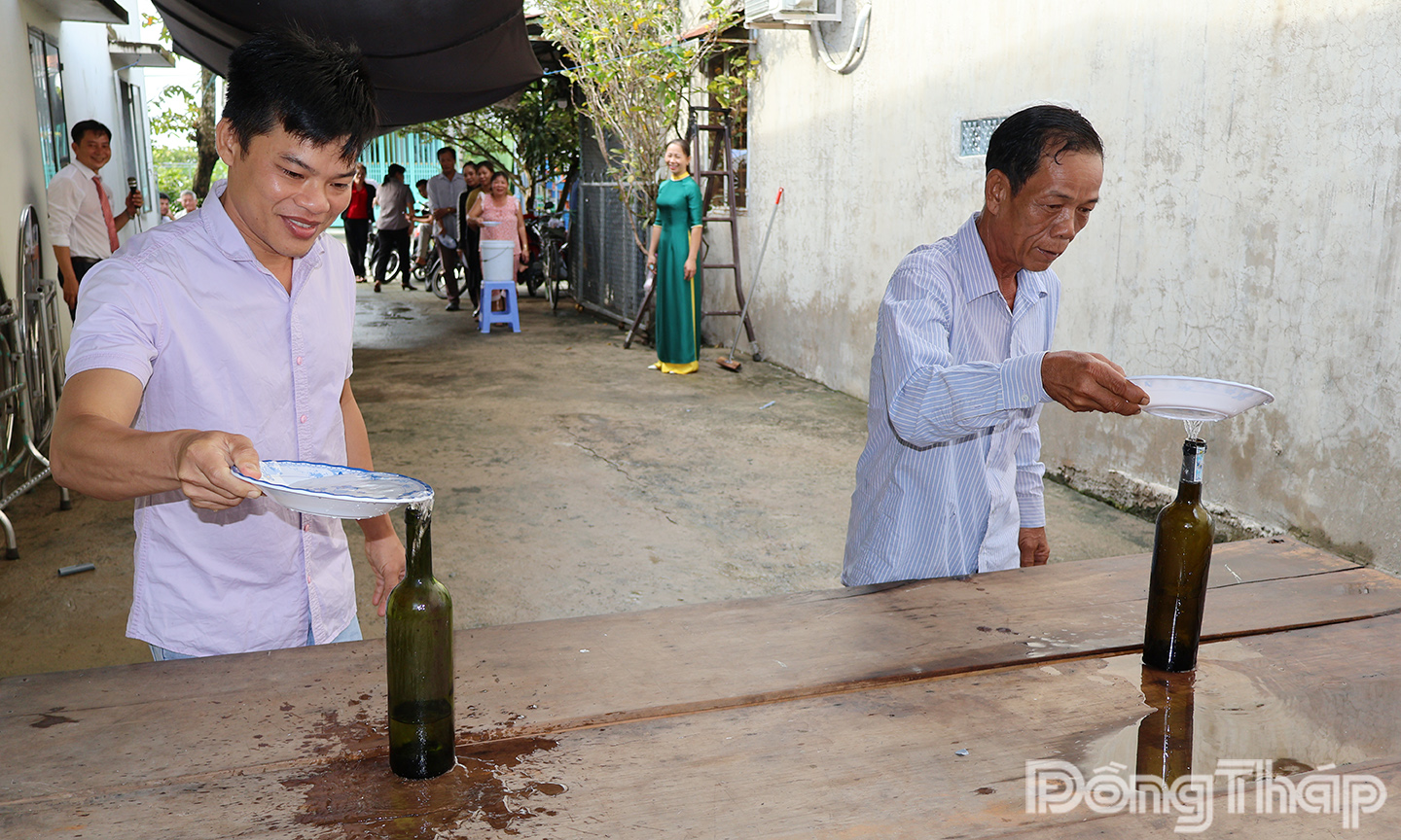 Người dân ấp Mỹ Phước 1, xã Mỹ Quí tham gia chơi trò chơi chuyền nước vào chai tại Ngày hội Đại đoàn kết toàn dân tộc.