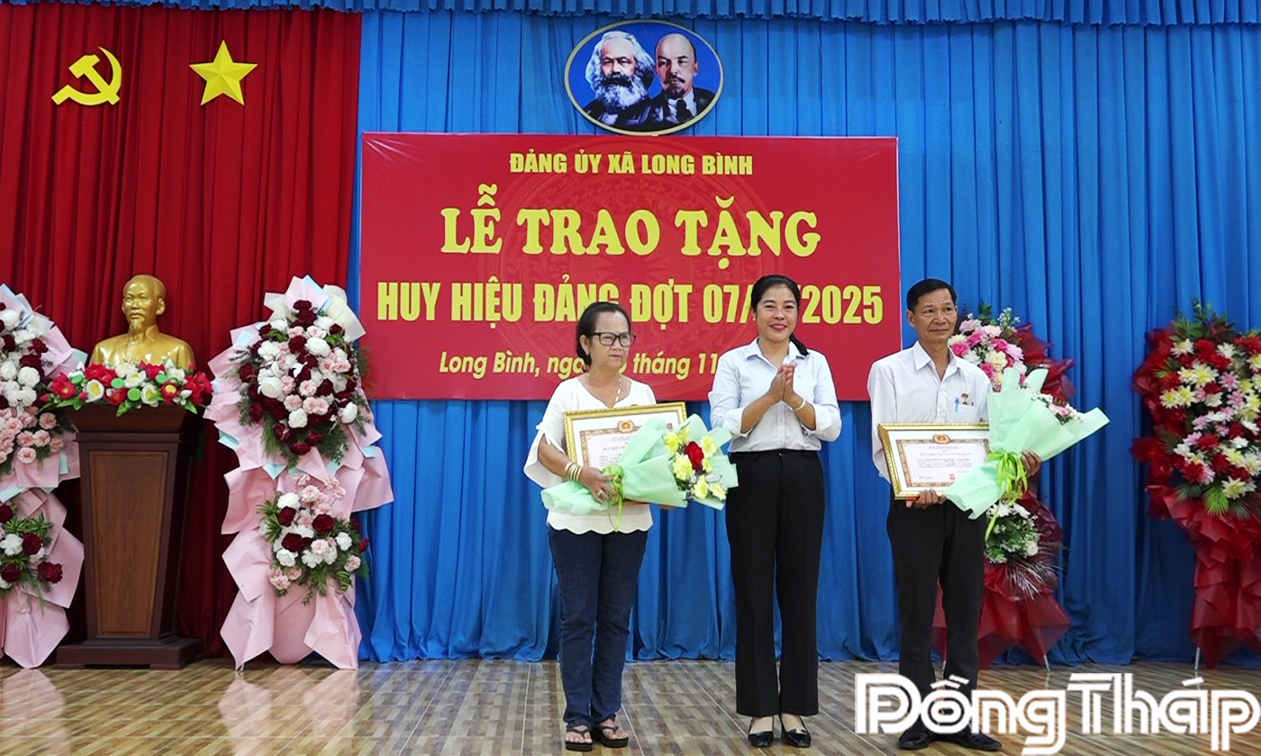 Đồng chí Đỗ Thị Kiều Oanh trao huy hiệu Đảng cho các Đảng viên