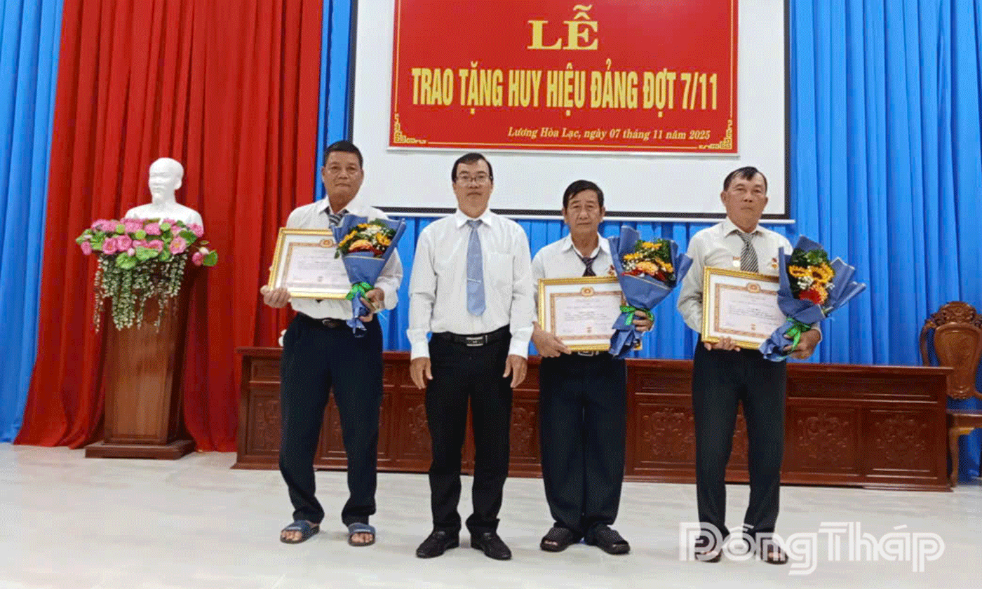 đồng chí Nguyễn Văn Mẹo, Bí thư Đảng ủy, Chủ tịch HĐND xã trao Huy hiệu Đảng cho các đảng viên.