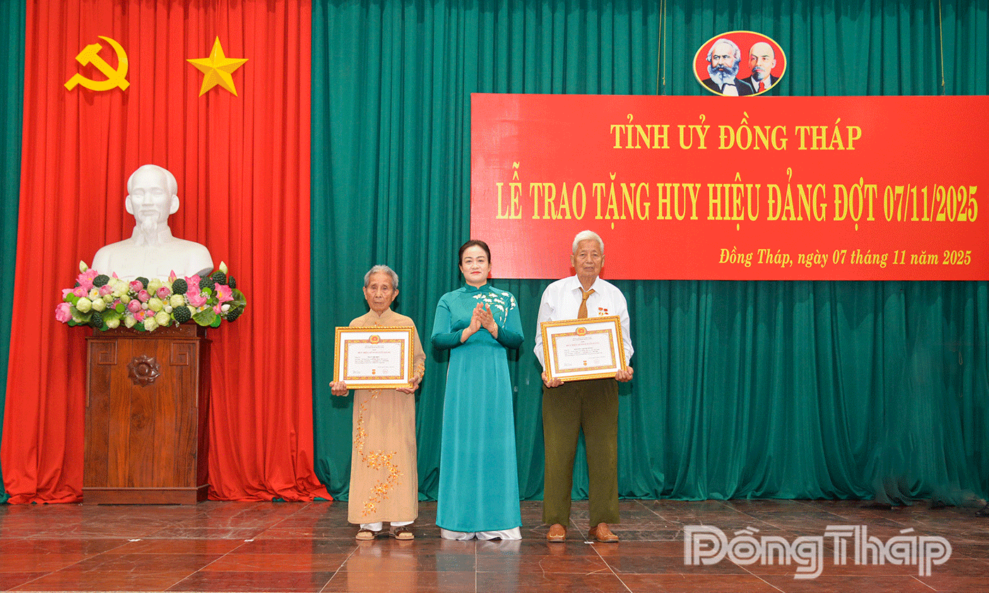 Đồng chí Nguyễn Hải Trâm, Phó Bí thư Thường trực Tỉnh ủy trao Huy hiệu 65 năm tuổi Đảng và tặng khánh, hoa cho 2 đảng viên: Trần Thị Biểu và Nguyễn Thanh Hùng.