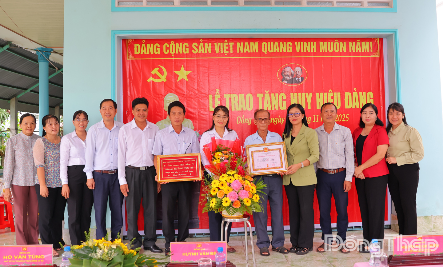 Đồng chí Nguyễn Thị Kim Tuyến, Ủy viên Ban Thường vụ Tỉnh ủy, Trưởng Ban Tuyên giáo và Dân vận Tỉnh ủy Đồng Tháp cùng đại diện cấp uỷ xã Mỹ Thọ chụp ảnh lưu niệm cùng đảng viên Huỳnh Văn Bé.