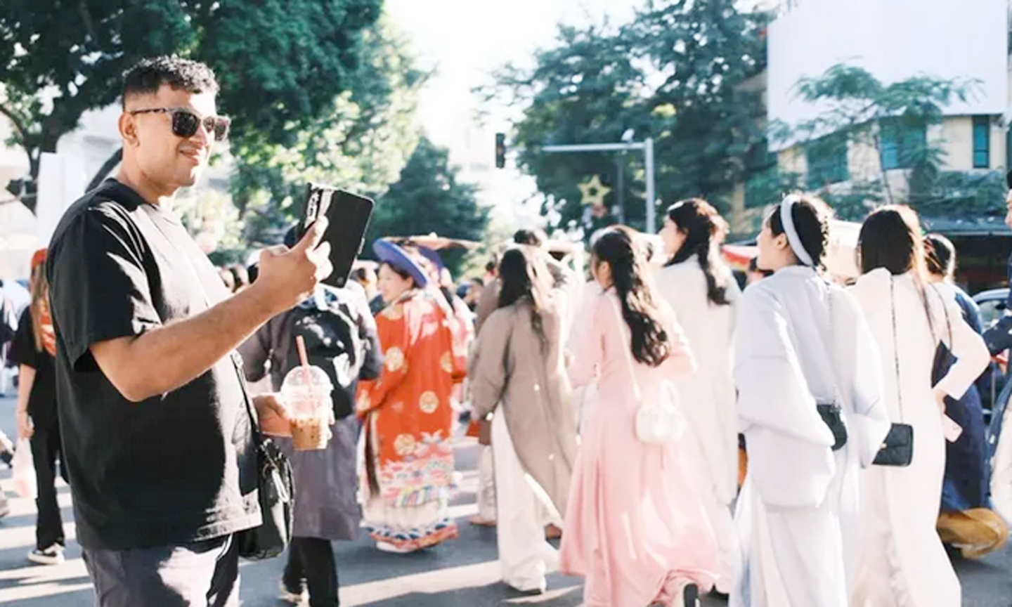 Du khách lưu lại khoảnh khắc trong lễ diễu hành Ngày hội Việt phục diễn ra tại Hà Nội, ngày 15-11.