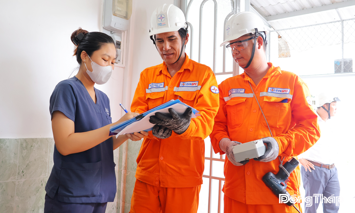 Đội Quản lý điện Mỹ Tho cho khách hàng kiểm tra thông tin và ký xác nhận biên bản treo tháo công tơ điện tử mới cho khách hàng ở phường Mỹ Tho.