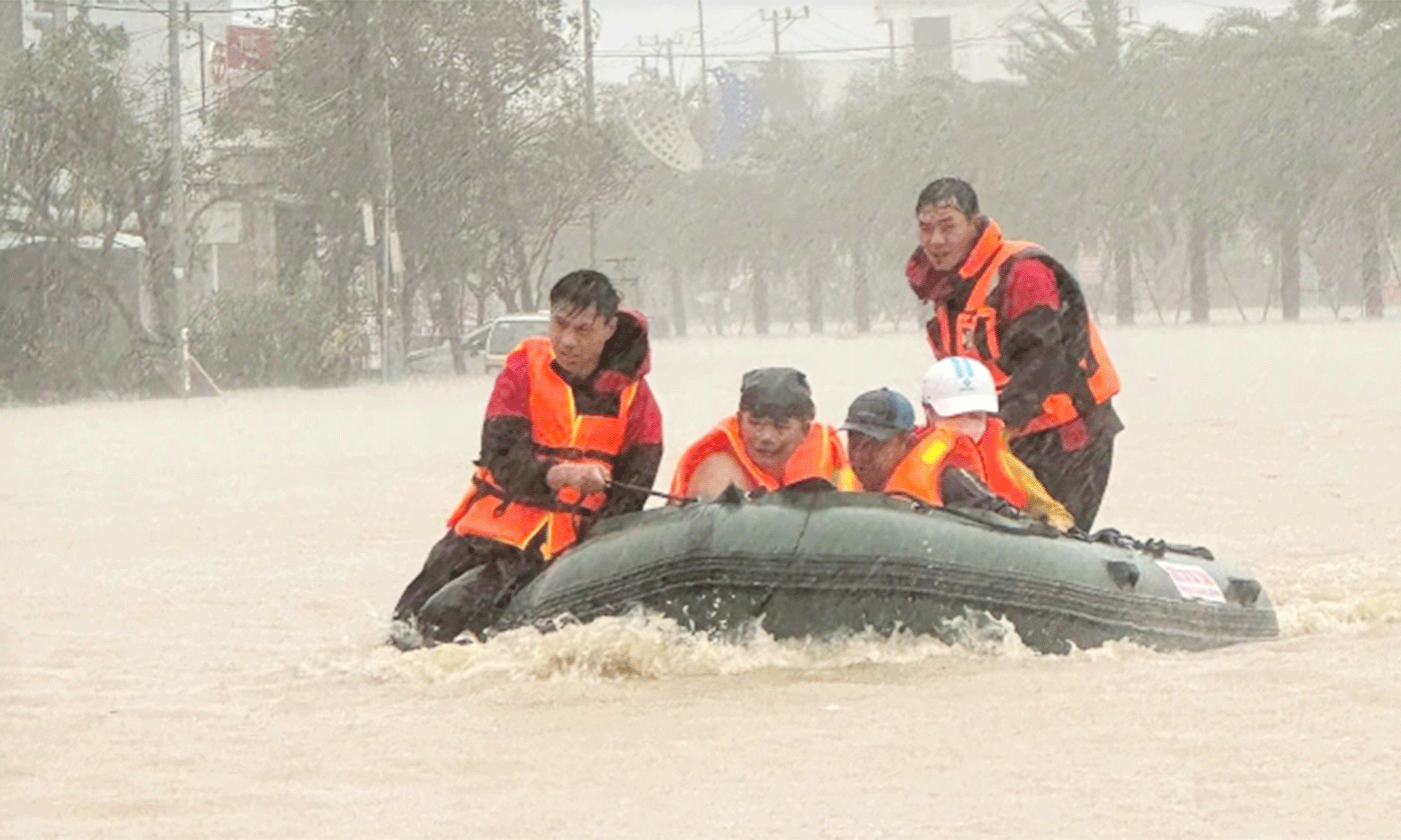 Các thành viên trong đội cứu hộ SOS 38 Hà Tĩnh đưa người dân bị cô lập trong nước lũ tại phường Quy Nhơn Bắc, Gia Lai đến nơi an toàn, ngày 19-11. Ảnh: Lương Vĩnh Long Nhật